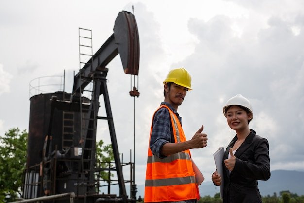 female-engineers-consult-with-workers-working-oil-pumps-with-sky_1150-19222