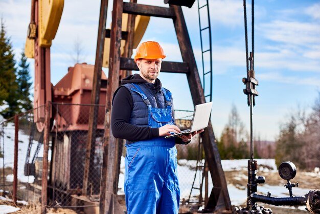 oil-engineer-with-laptop-standing-oil-rig-making-notes-his-computer_651396-3042